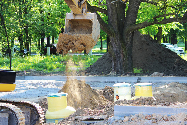 Excavadora cava a tanque de plástico de gas captador de petróleo en el suelo durante la construcción de un aparcamiento para autobuses turísticos, Rusia
 - Foto, imagen