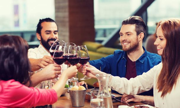 friends dining and drinking wine at restaurant - Fotoğraf, Görsel