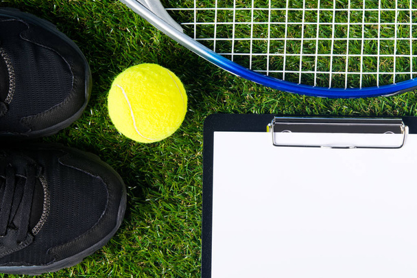 Set for playing tennis lies on a green lawn as a background - Фото, изображение