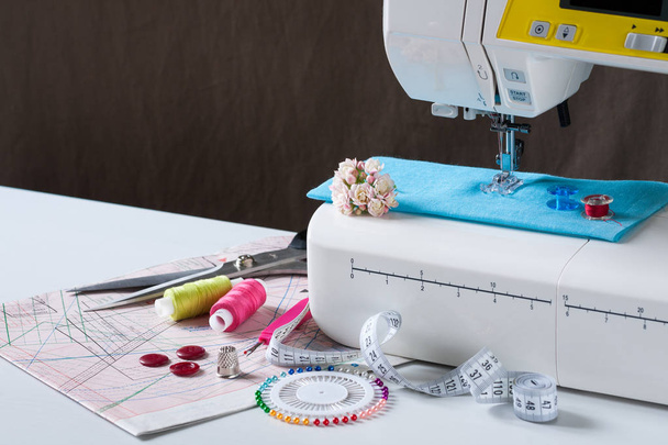 Sewing Machine With Different Accessories On White Table. - 写真・画像