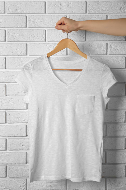 Blank white t-shirt against brick wall - Фото, зображення