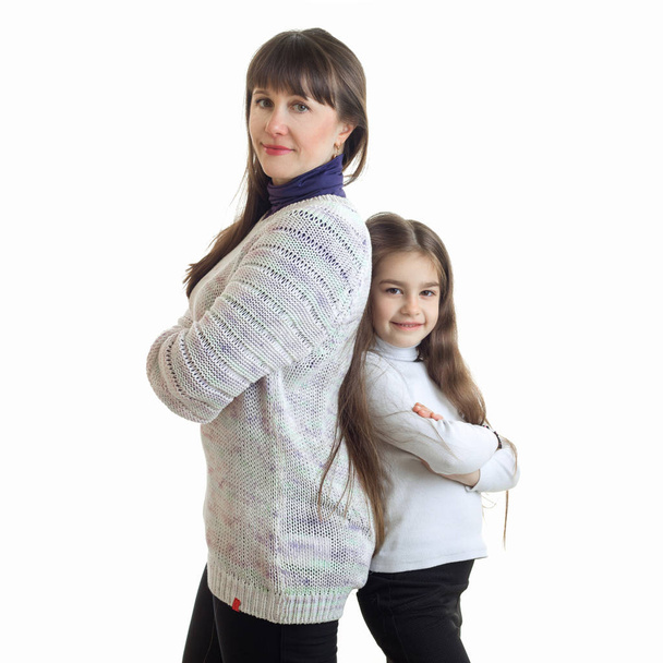 square portrait of mother and daughter smiling and standing back to back - Foto, Imagen