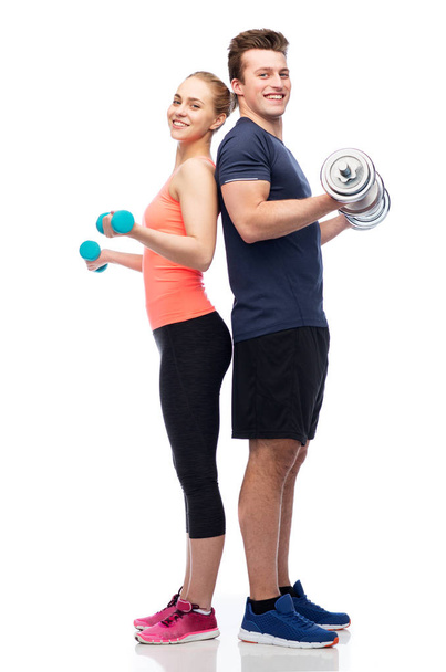 sportive man and woman with dumbbells - Photo, Image