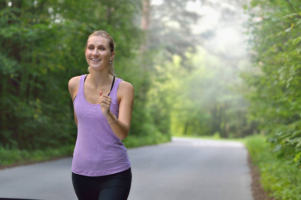 Kobiece Runner joggingu podczas treningu odkryty w parku. - Zdjęcie, obraz