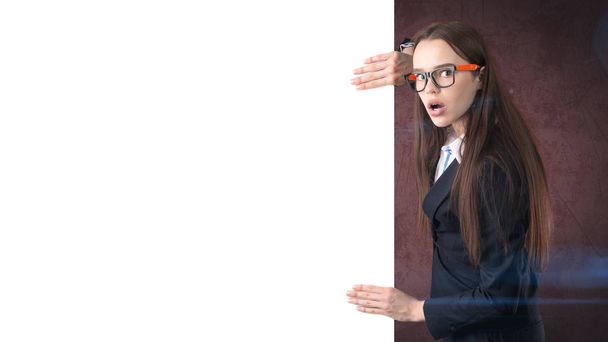 Surprised Business woman portrait with blank white board on brown isolated . Female model with long hair in glasses. - Foto, Bild