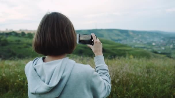Mujer toma un hermoso paisaje en los teléfonos de cámara
. - Metraje, vídeo