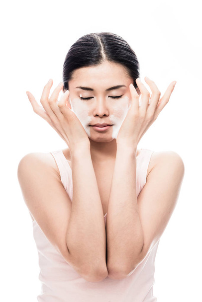 Frau trägt Gesichtscreme auf  - Foto, Bild