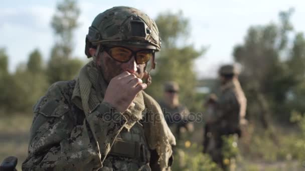 Soldado fumando em frente a outros soldados
 - Filmagem, Vídeo