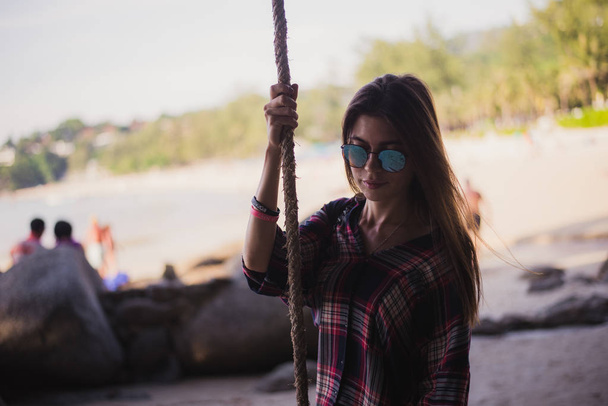 Cute girl posing on a beach. She holds a rope and looking far away. Perfect photo for a fashion store - Foto, imagen
