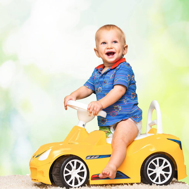 cute boy in yellow toy car - 写真・画像