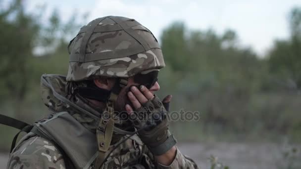 Man putting camouflage on face - Footage, Video