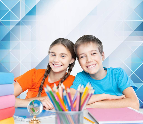  Дети сидят за столом во время урока
 - Фото, изображение