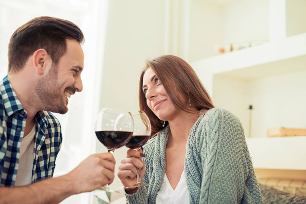  若い夫婦が赤ワインを飲んで - 写真・画像