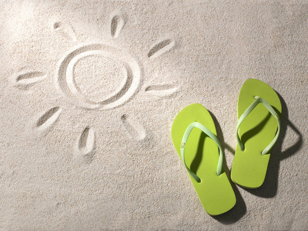 chinelos na praia de areia com símbolo de sol
 - Foto, Imagem