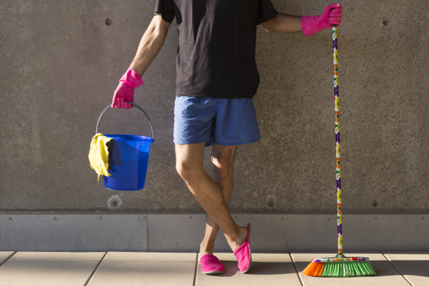 casa marido en zapatillas de color rosa la limpieza del suelo
 - Foto, Imagen