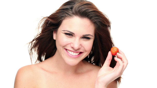 krásná žena jíst jahody proti Bílému pozadí - Záběry, video