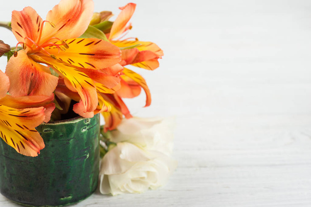 Arrangement of orange lily flowers in green pot - Photo, Image