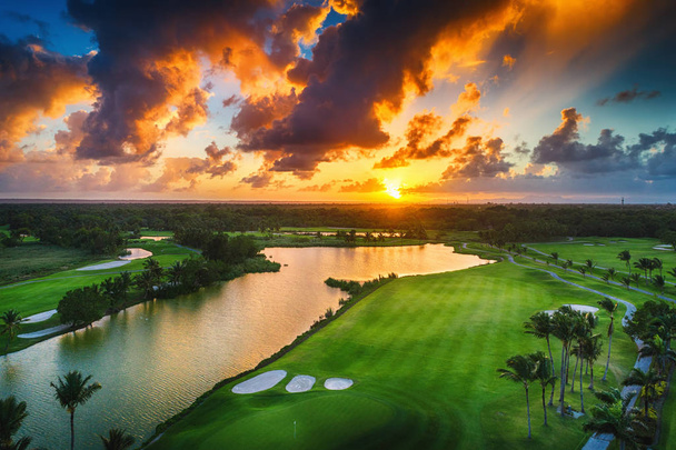 Вид с воздуха на тропическое поле для гольфа на закате, Доминиканская Республика
 - Фото, изображение