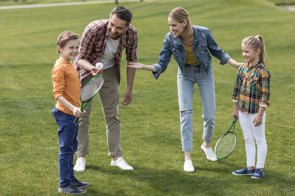 happy family playing badminton in park - Фото, изображение
