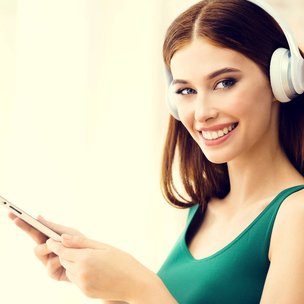 Young woman listening headphones, indoors.  - Fotó, kép