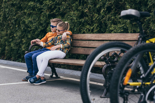 stylish kids resting on bench at park - Photo, Image