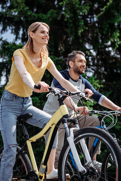casal sorrindo andar de bicicleta no parque
 - Foto, Imagem