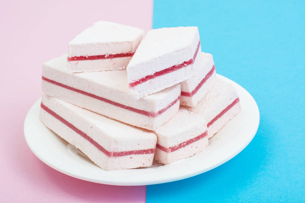 White marshmallow with cranberry layer on pastel background. - Photo, Image