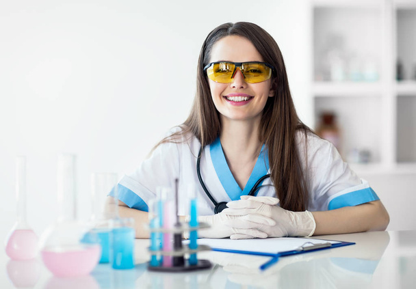 Smiling scientist in chemical laboratory - Фото, изображение