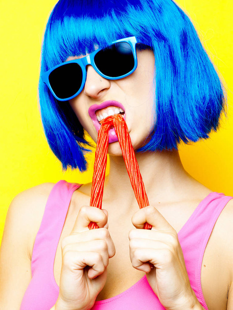 Молодая сексуальная девушка в синем парике, голубых солнцезащитных очках и розовых ботинках
 - Фото, изображение