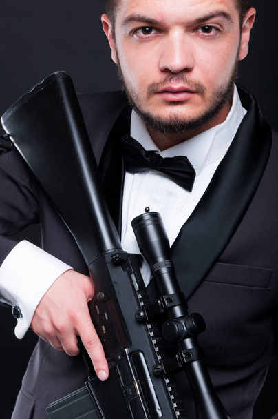 Portrait of young gangster holding armed rifle - Fotografie, Obrázek