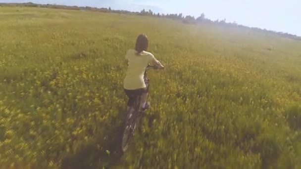 Girl riding a bicycle on the field - Πλάνα, βίντεο