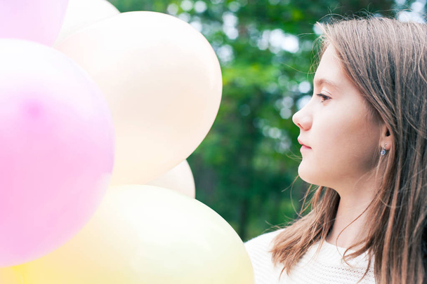 Jolie jeune adolescente souriante avec des ballons multicolores pain
 - Photo, image