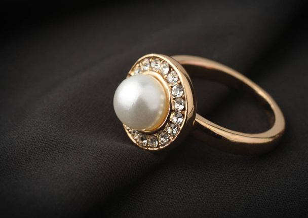 jewelry ring with pearl on black cloth, soft focus - Foto, afbeelding