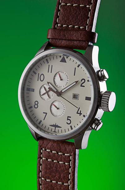 Man's metal wristwatch without logos on green background - Photo, Image