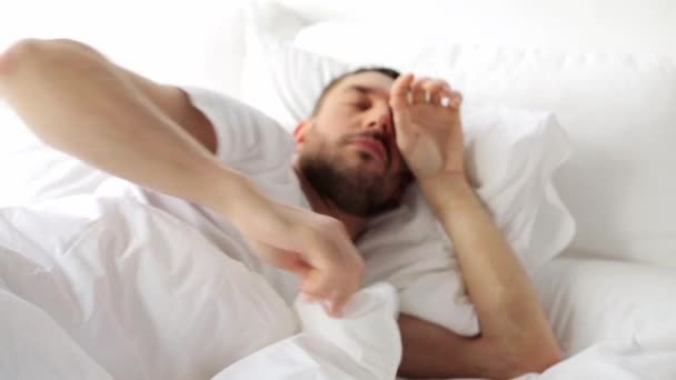man waking up in bed at home - Video