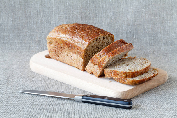 Sliced wholegrain bread on a wooden table - Фото, изображение