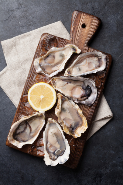 Opened oysters and lemon over ice - Photo, Image