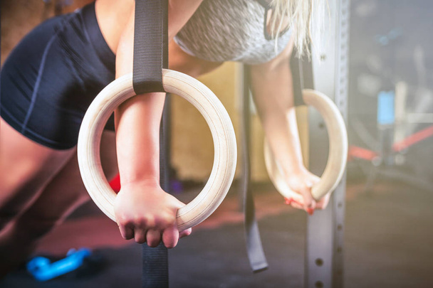 Woman working out with gymnastic rings at crossfit gym - Foto, Imagem