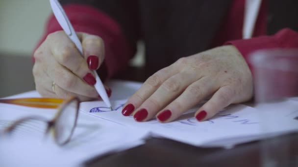 Female hands drawing something on a paper - Materiał filmowy, wideo