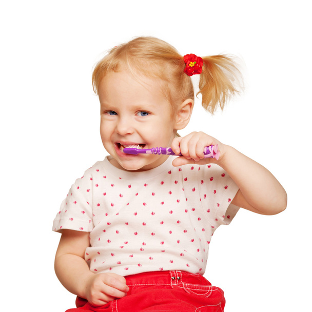 Kaunis tyttö harjaamassa hampaitaan.
. - Valokuva, kuva