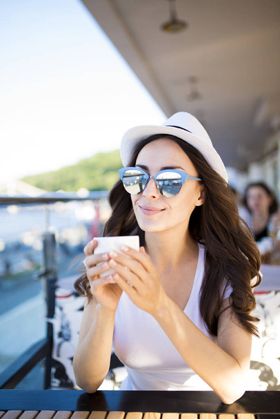 woman in sunglasses drinking coffee  - Фото, изображение