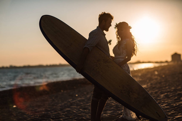 Happy surfers couple standing with surfboards on the sandy beach - Foto, Bild
