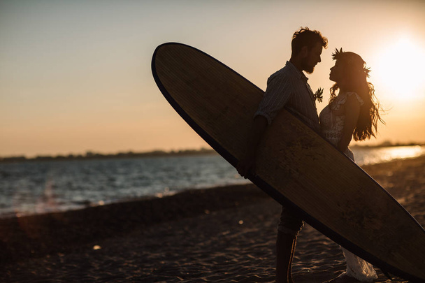 Happy surfers couple standing with surfboards on the sandy beach - Foto, Imagem