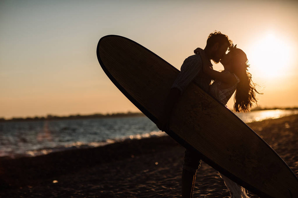 Happy surfers couple standing with surfboards on the sandy beach - Foto, Imagen