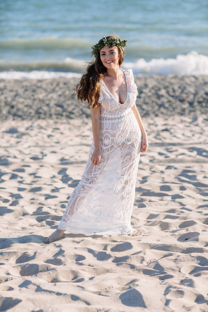 Beautiful girl on the beach in a beautiful dress. Sunny day, white sand, boho - Foto, afbeelding