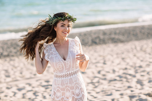Beautiful girl on the beach in a beautiful dress. Sunny day, white sand, boho - Фото, изображение