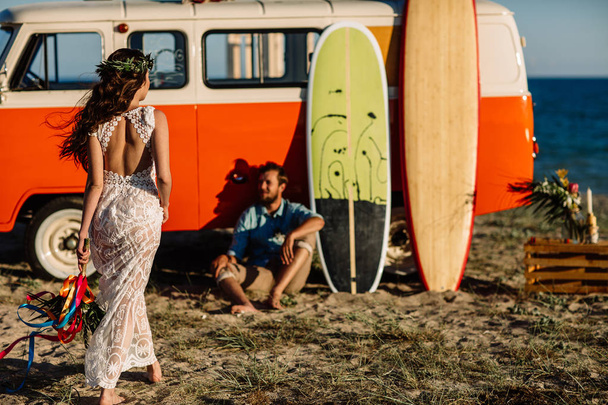 Happy surfers couple standing with surfboards on the sandy beach - Photo, Image