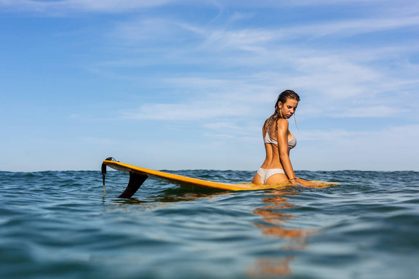 One beautiful sporty girl surfing in the ocean. - Фото, зображення