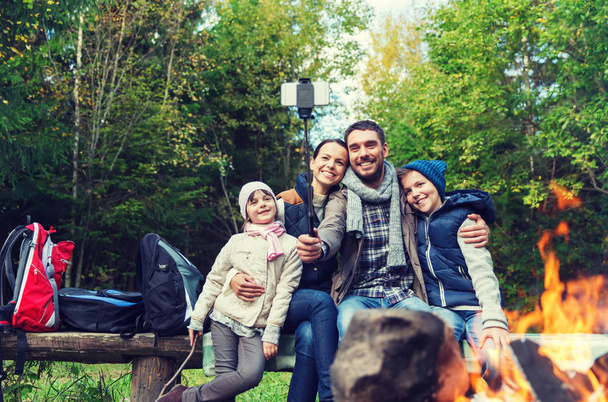 family with smartphone taking selfie near campfire - Foto, Imagen