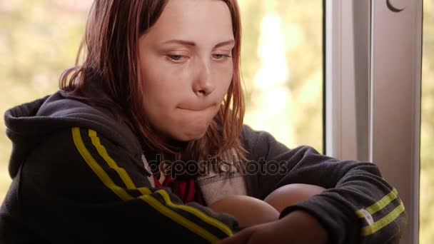 Depressed girl at home. Sad girl near window. - Materiał filmowy, wideo